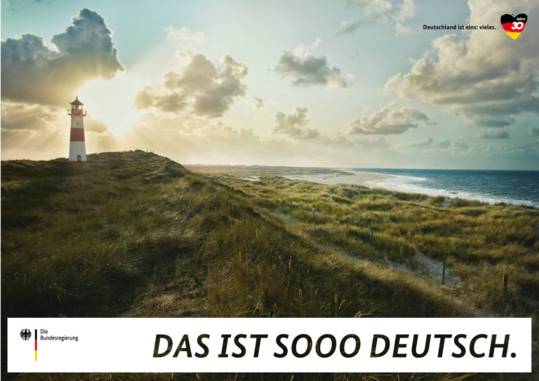 Ein Leuchtturm am Meer auf einem Plakat der Kampagne "Deutschland ist eins: vieles".